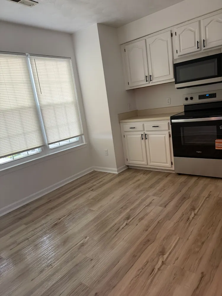 Clean kitchen with white cabinets and range