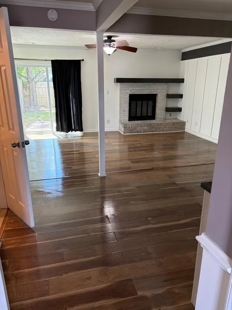 Living room with shining wood floors and a brick fireplace