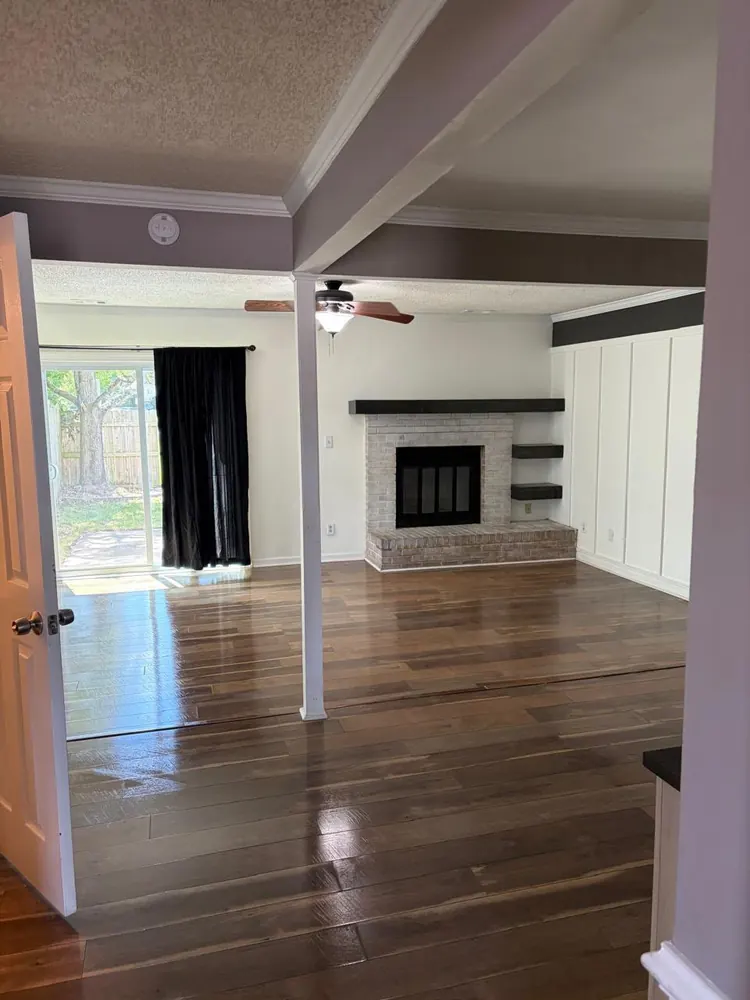 Living room with shining wood floors and a brick fireplace